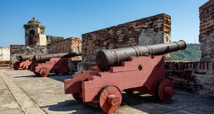 Alte Kanonen auf einer Festungsmauer mit Blick auf einen klaren blauen Himmel.
