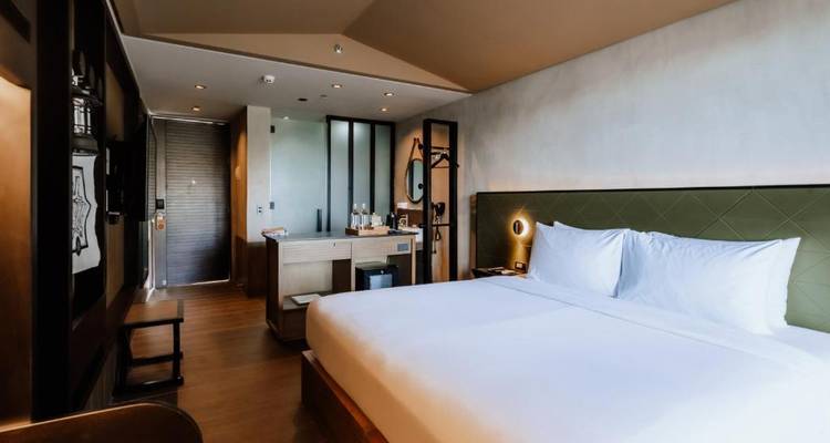 Modernes Hotelzimmer mit minimalistischem Design und großem Bett.