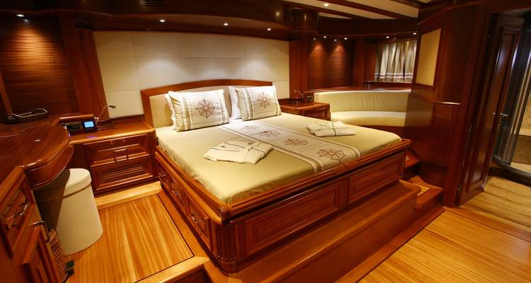 Intérieur luxueux d'une chambre de yacht avec du bois poli et une décoration élégante.