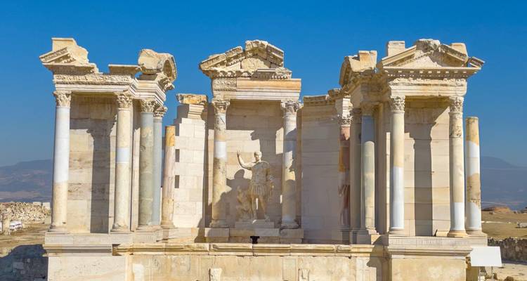 Anciennes ruines de marbre d'une structure historique contre un ciel bleu.