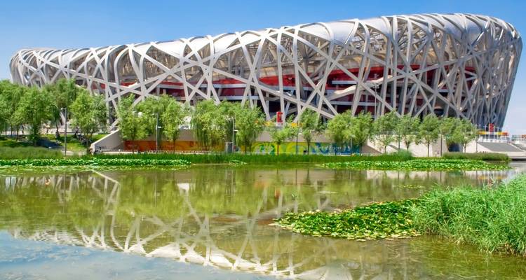 Le Stade national de Pékin reflété dans un étang.