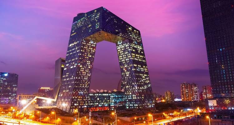 Le bâtiment du siège de CCTV illuminé par les lumières du paysage urbain au crépuscule.