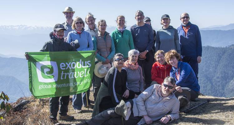 Grupo de personas posando en la cresta de una montaña con una pancarta.