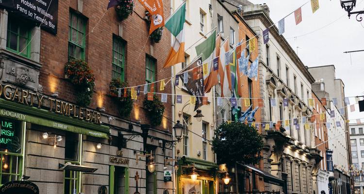 Een straatbeeld in Dublin met kleurrijke vlaggen en winkels.