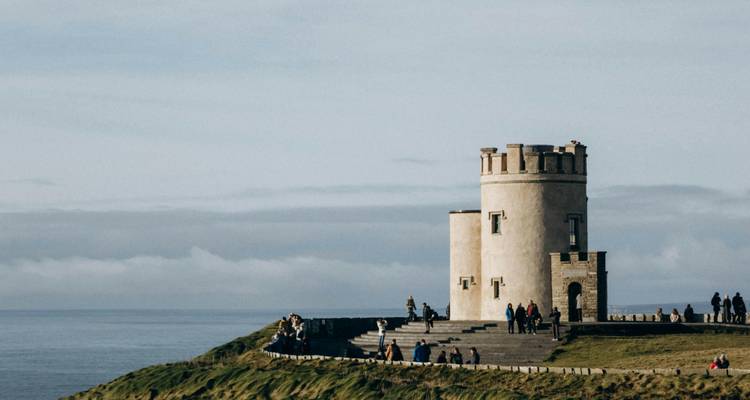 Een kasteel met mensen op de Cliffs of Moher.
