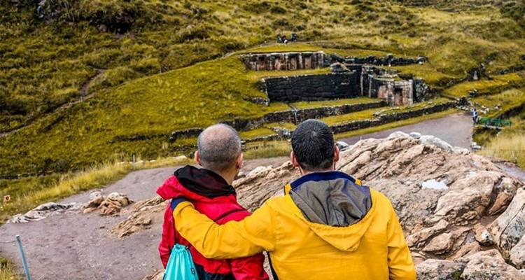 Des touristes admirant des ruines antiques dans une vallée.