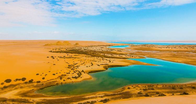 Een woestijnlandschap met een turquoise lagune.