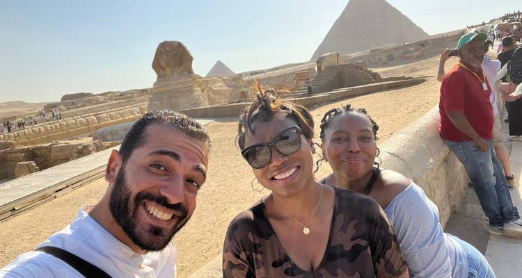 Des personnes posant avec le Sphinx et les pyramides en arrière-plan.