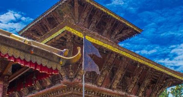 Nahaufnahme eines traditionellen nepalesischen Tempeldachs mit kunstvoller Holzarbeit.