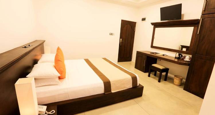 Einfaches Hotelzimmer mit modernen Möbeln und heller Beleuchtung.