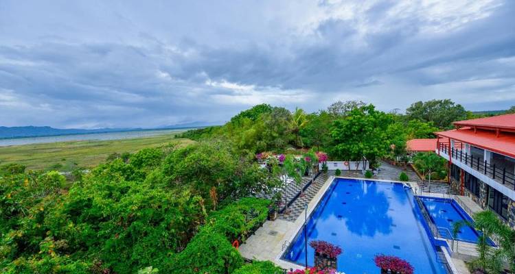 Außenpool mit weitem Blick auf grüne Landschaft an einem bewölkten Tag.