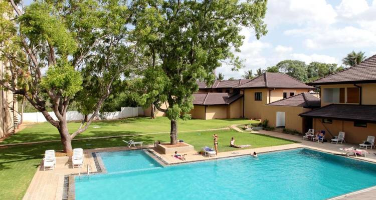 Außenpool-Bereich in einer Hotelanlage mit schwimmenden und sich entspannenden Menschen.