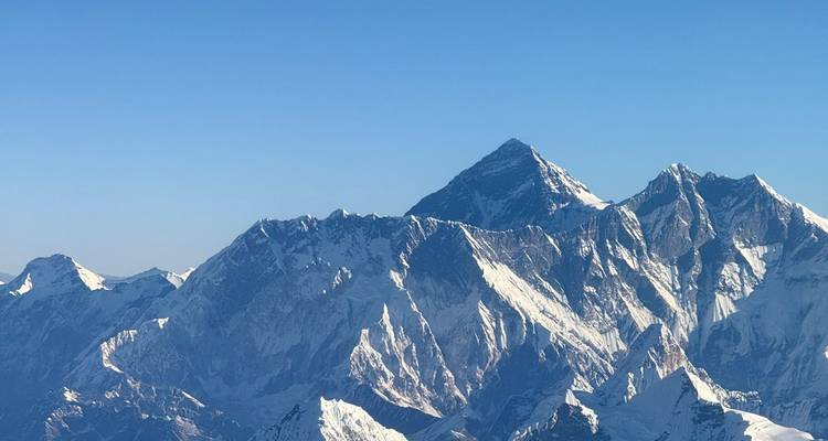 Vue majestueuse de montagnes enneigées sous un ciel lumineux.