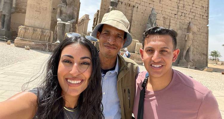 Trois personnes prenant un selfie dans un temple égyptien.