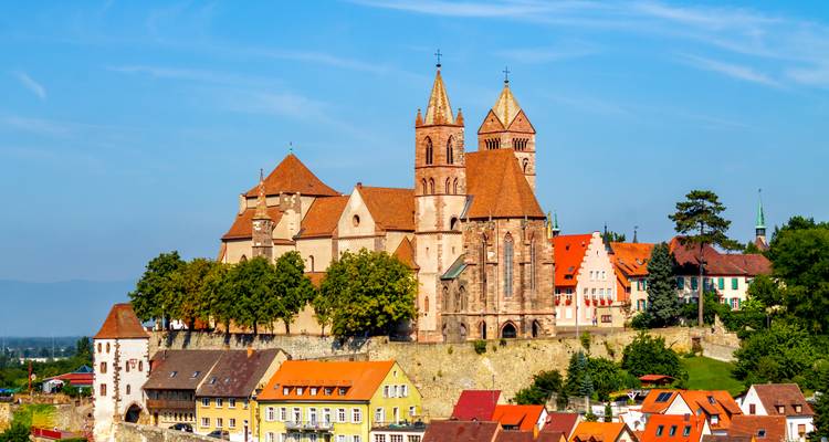 Complexe de cathédrale médiévale au sommet de la colline fortifiée de Breisach sous un ciel bleu dégagé.