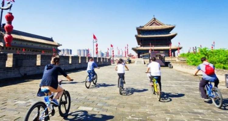 Groupe de personnes faisant du vélo sur un rempart historique.