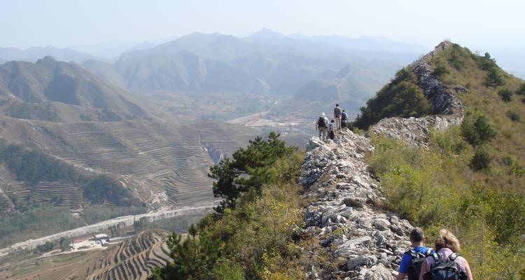 Senderistas en un sendero con amplias vistas de las montañas.