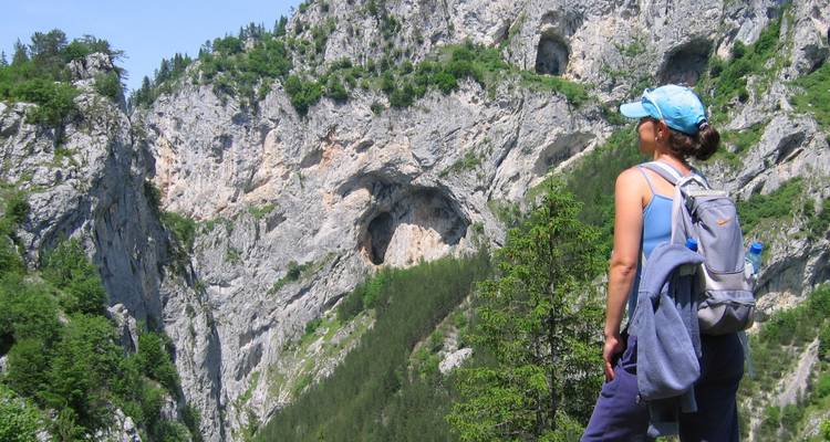 Personne avec un sac à dos regardant un paysage de montagne accidenté.