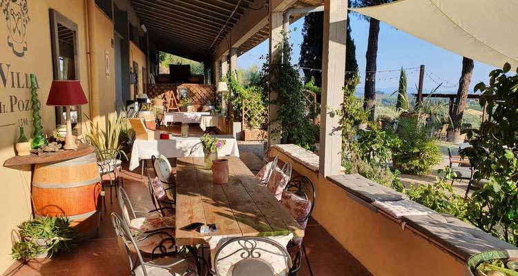 Charmant villa terras met rustieke houten tafels met uitzicht op Toscaanse landelijke tuinen.