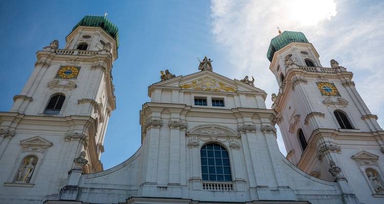 Toma en contrapicado de las torres gemelas de cúpulas verdes de la Catedral de Passau contra un cielo brillante.