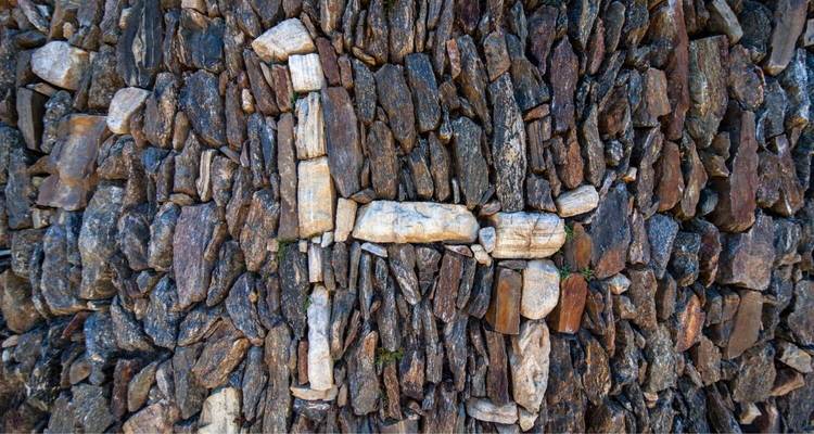 Gros plan d'un mur de pierre aux motifs complexes.