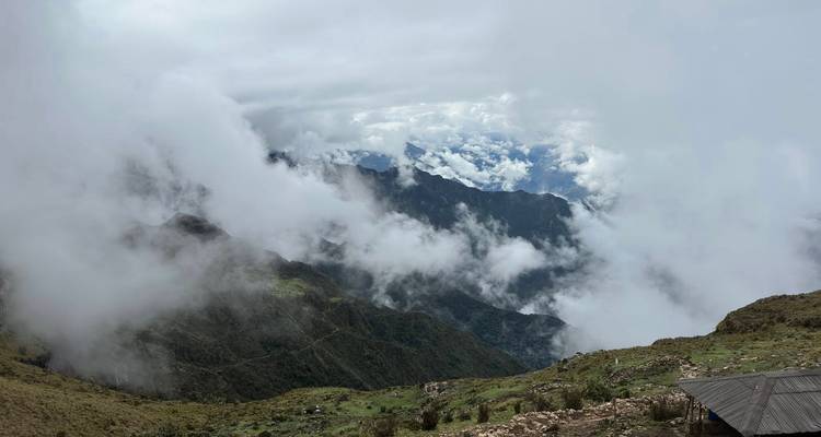 Paysage de montagne brumeux avec falaises et nuages.
