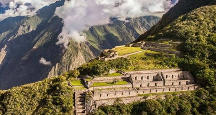 Vue panoramique des ruines de Choquequirao au milieu de montagnes imposantes.