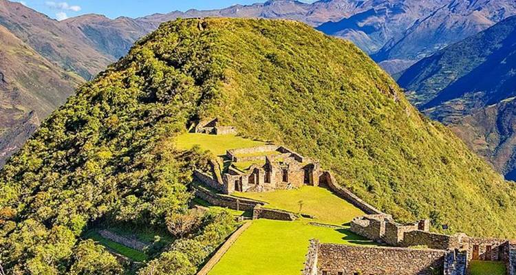 Vue aérienne des ruines de Choquequirao avec des montagnes en arrière-plan.