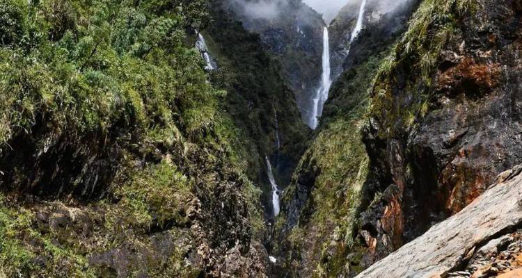 Un paysage verdoyant luxuriant avec une cascade dans une région montagneuse.