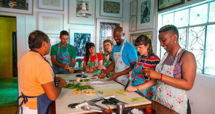 Cours de cuisine avec un groupe de personnes diverses préparant de la nourriture ensemble.