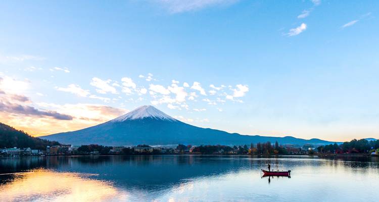 Le mont Fuji se reflétant dans un lac au lever du soleil.