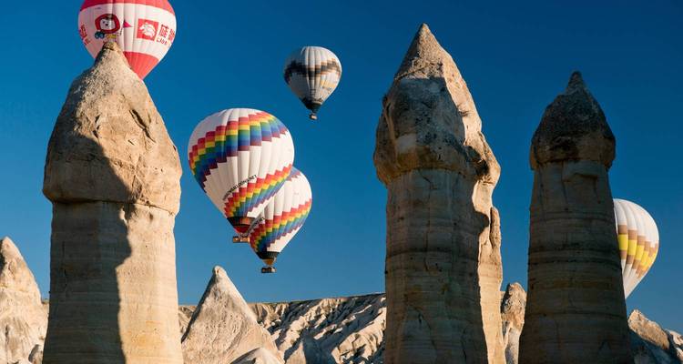 Montgolfières volant au-dessus de formations rocheuses uniques.