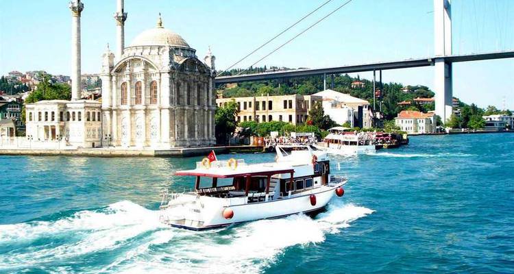Bateau naviguant sur le Bosphore avec une mosquée et un pont en arrière-plan.