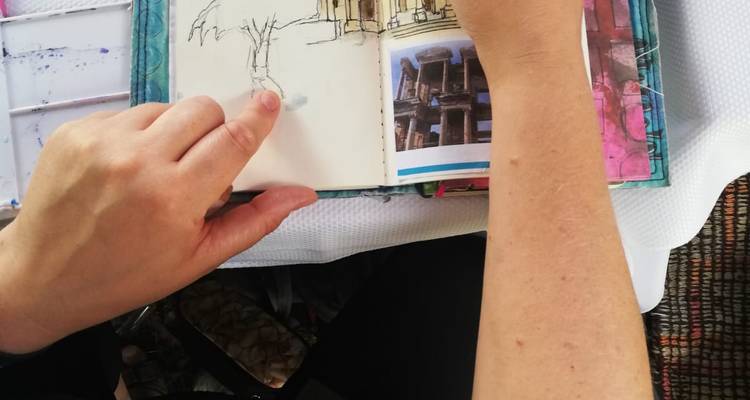 Personne dessinant dans un carnet de croquis de lieux historiques.