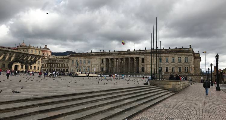 Large place de pierre avec pigeons et bâtiment du Capitole National à Bogota sous de lourds nuages gris