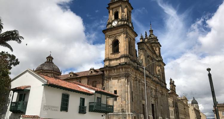 Cathédrale coloniale en pierre avec tour d'horloge et ciel bleu avec nuages effilés dans le quartier historique de Bogota