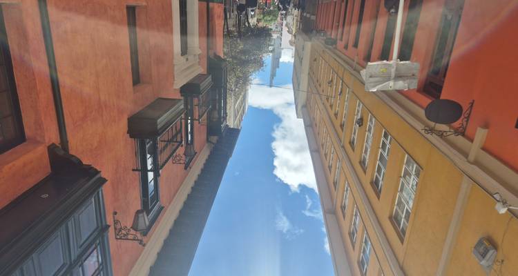 Kleurrijke steeg met zonnestralen en koloniale gevels in Bogotá's historische wijk.