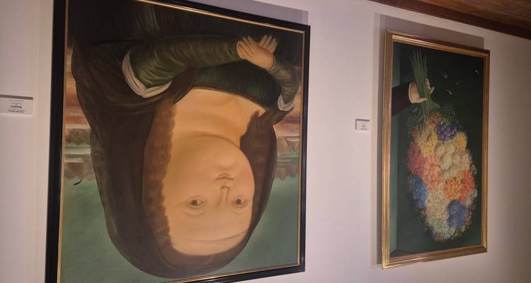 Schilderijen van Fernando Botero uitgesteld in een goed verlichte galerieruimte.