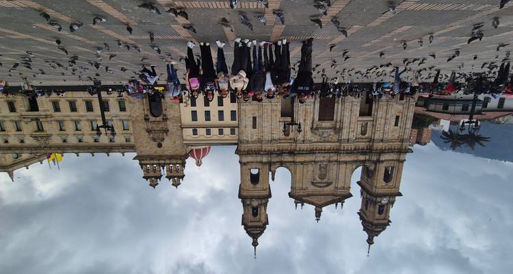 Toeristengroep poseert voor de kathedraal van Bogotá op Plaza de Bolívar, omringd door duiven.