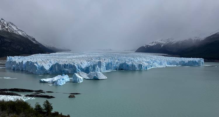 Uitgebreid vooraanzicht van Perito Moreno-gletsjer onder grillige grijze lucht.