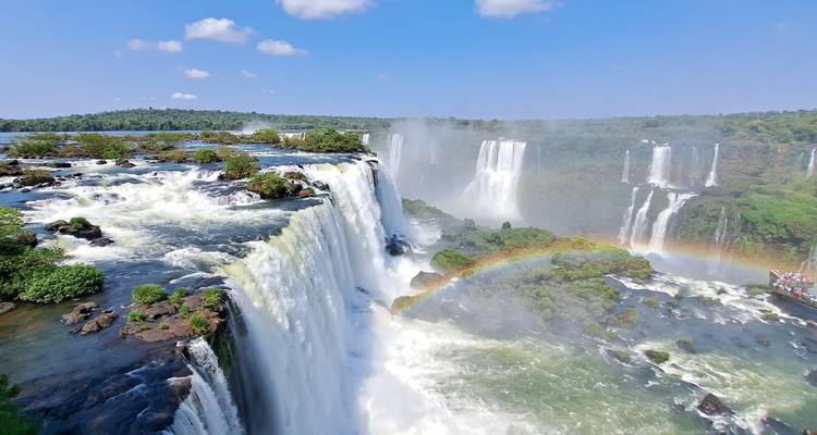 De dramatische Iguazú-watervallen storten omlaag met een levendig regenboogje dat door de waternevels bogen vormt.