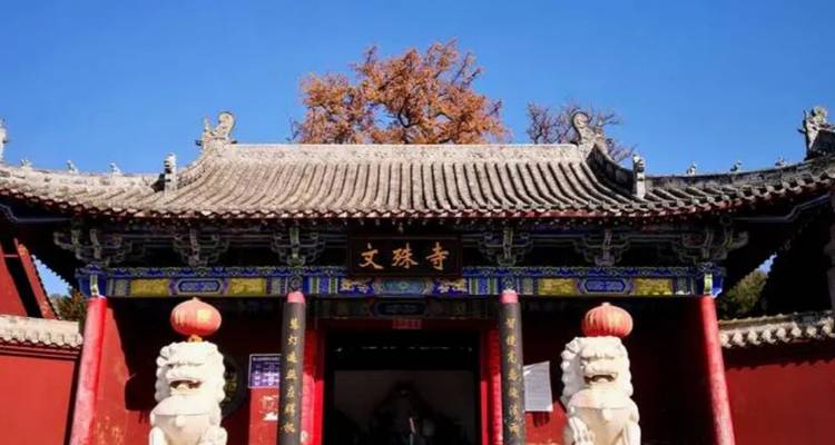 Entrada de templo chino tradicional con estatuas de leones.