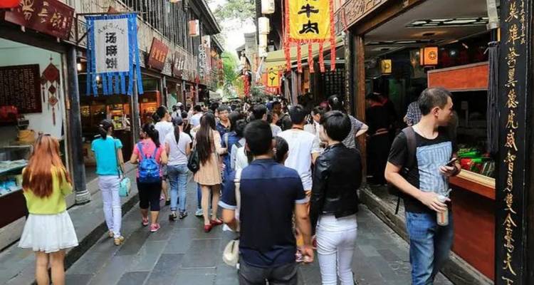 Calle concurrida con tiendas vibrantes y gente.