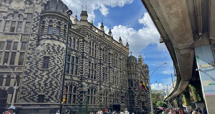 Die neugotische gemusterte Fassade des Palacio de la Cultura in Medellín ragt neben einer erhöhten Metrotrasse empor.