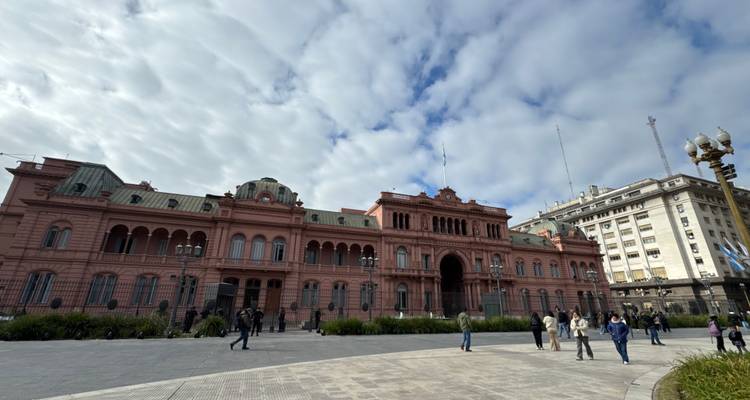 Het roze getinte Casa Rosada presidentieel paleis domineert het Plaza de Mayo onder een dramatische wolkenrijke hemel.