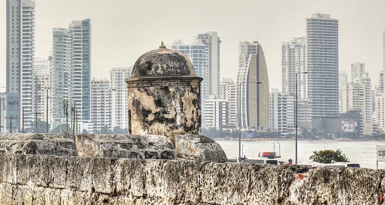 Ancienne tourelle en pierre des fortifications de Carthagène avec les gratte-ciel modernes de Bocagrande de l'autre côté de la baie.