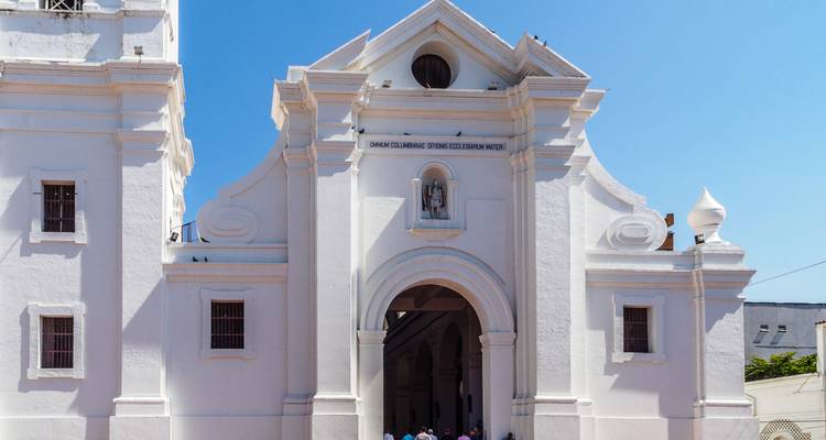 Façade avant de la cathédrale Santa Marta d'un blanc éclatant se détachant sur un ciel bleu limpide.