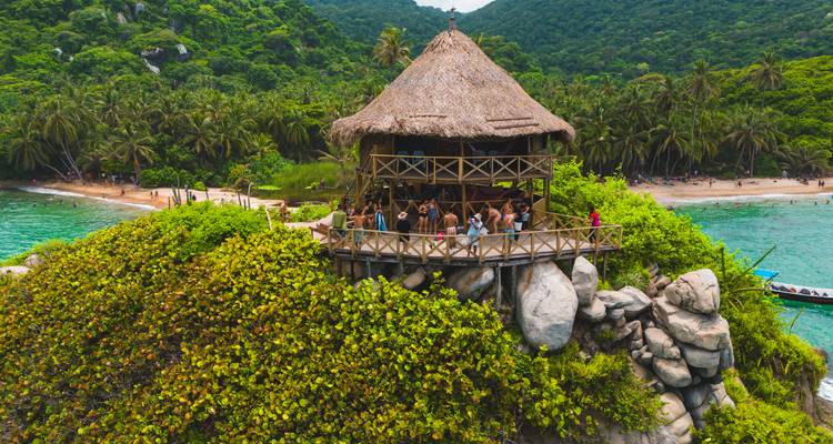 Les visiteurs se rassemblent dans une cabane d'observation en bois perchée au-dessus d'une végétation luxuriante entre deux plages de Tayrona.
