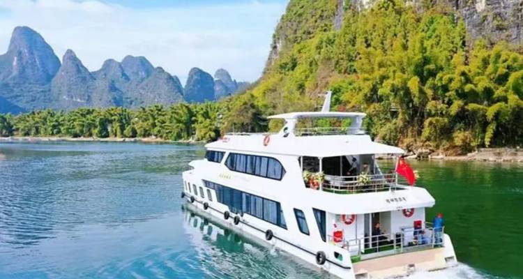 Un bateau naviguant sur une rivière avec des montagnes karstiques en arrière-plan.