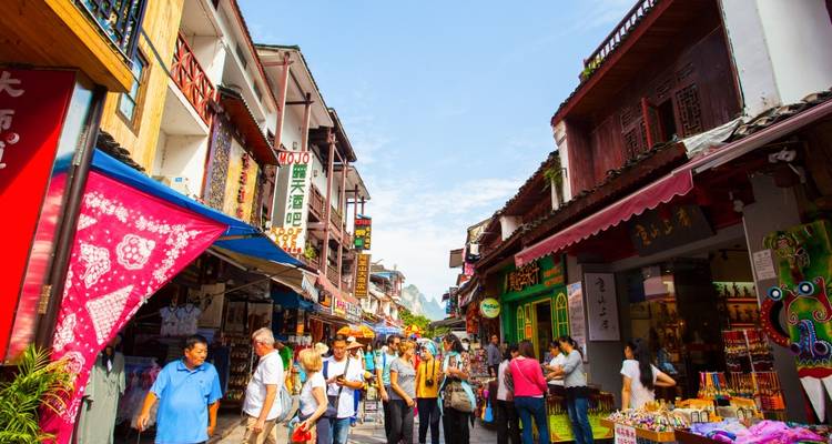 Un marché de rue coloré grouillant de monde pendant la journée.